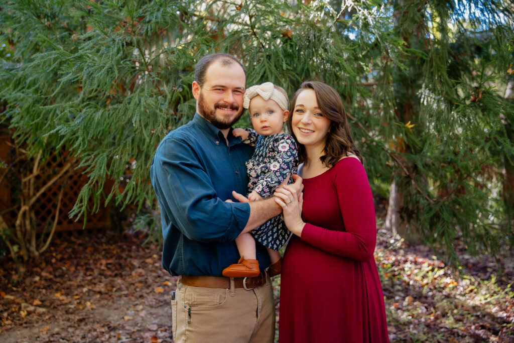 smiling family in maternity clothes. Mom wearing thrifted maternity dress
